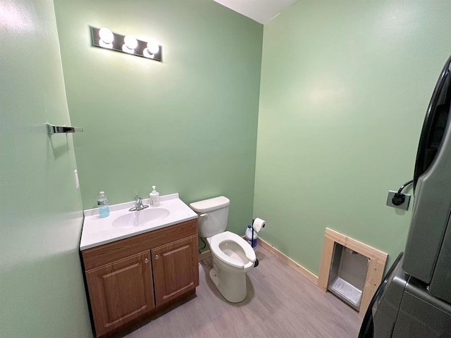 bathroom featuring hardwood / wood-style floors, vanity, and toilet