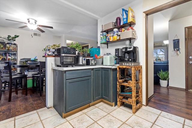 kitchen with gray cabinetry, ceiling fan, and light wood-type flooring