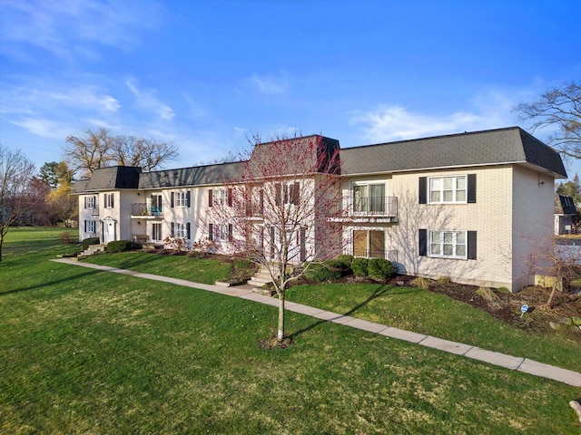 view of front facade featuring a balcony and a front lawn