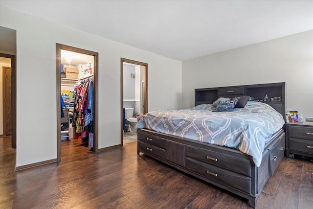 bedroom with a spacious closet, a closet, connected bathroom, and dark hardwood / wood-style floors