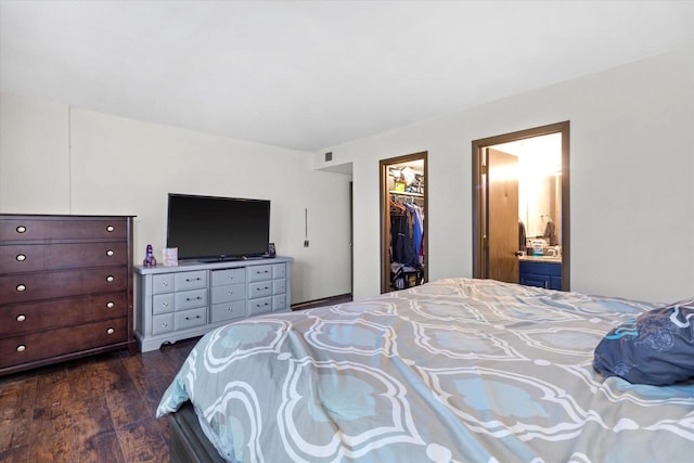 bedroom with dark hardwood / wood-style flooring, a walk in closet, ensuite bath, and a closet