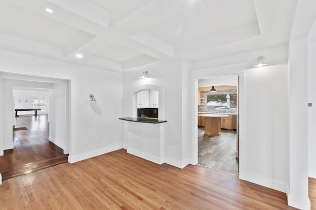 empty room with hardwood / wood-style flooring, a healthy amount of sunlight, and coffered ceiling