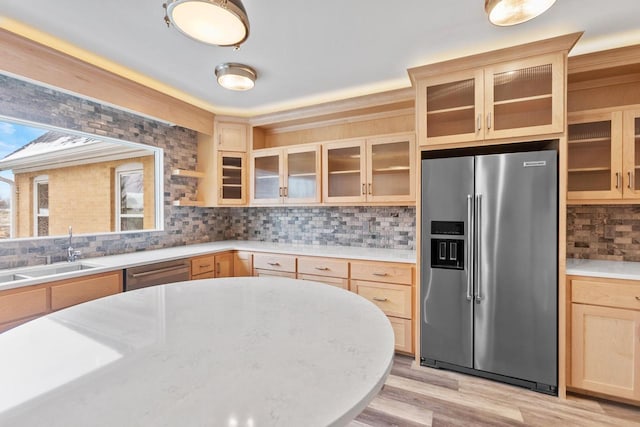 kitchen with sink, appliances with stainless steel finishes, tasteful backsplash, and light hardwood / wood-style flooring