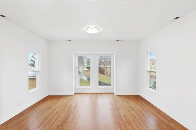 unfurnished room featuring a wealth of natural light and light hardwood / wood-style flooring