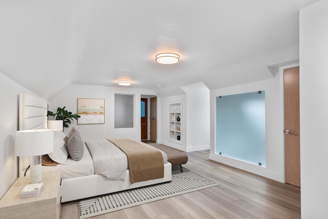 bedroom with light hardwood / wood-style floors and vaulted ceiling