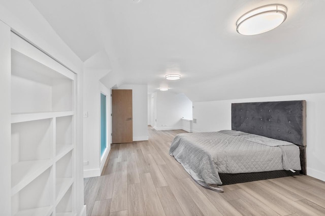 bedroom featuring vaulted ceiling and light hardwood / wood-style floors