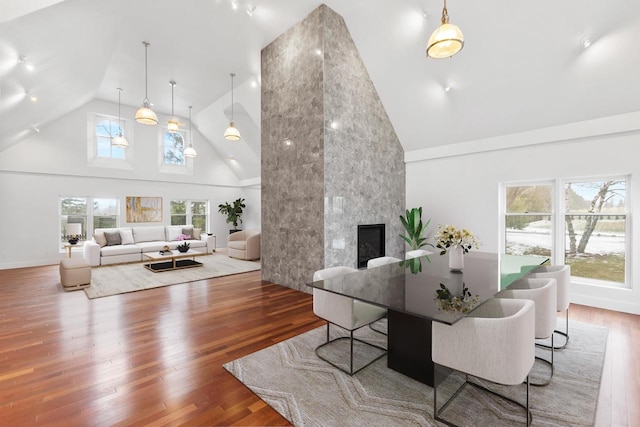 living room featuring high vaulted ceiling, hardwood / wood-style flooring, and a fireplace