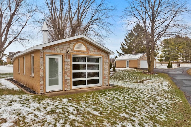 snow covered structure with a garage