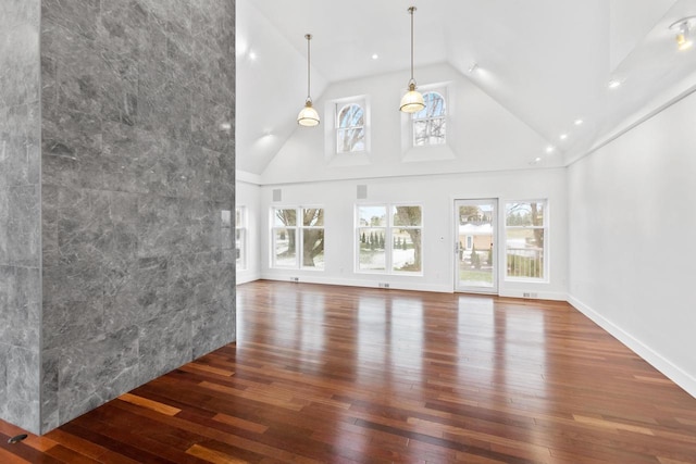 unfurnished living room with hardwood / wood-style floors and high vaulted ceiling