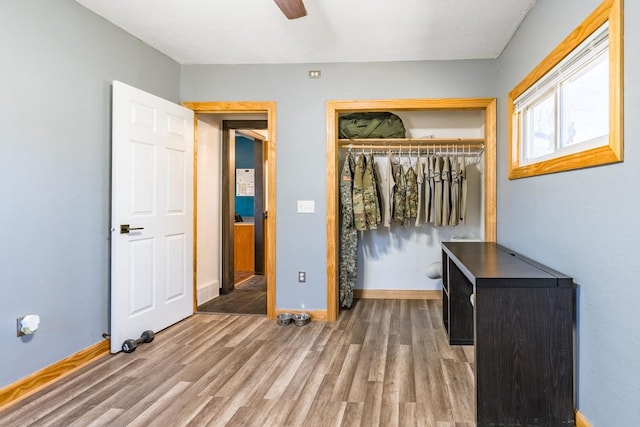 unfurnished bedroom with ceiling fan, a closet, and wood-type flooring