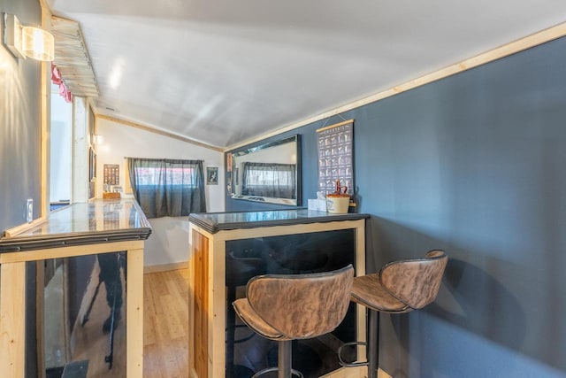 interior space with crown molding, light hardwood / wood-style floors, and vaulted ceiling