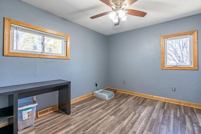 empty room featuring ceiling fan and dark hardwood / wood-style flooring