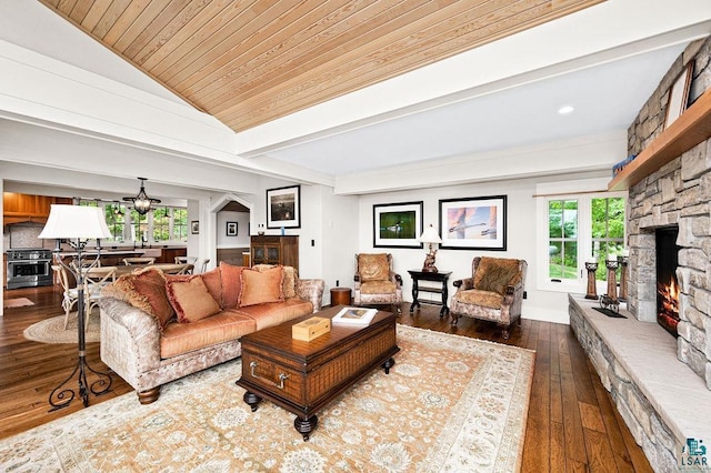 living room with dark hardwood / wood-style floors, ceiling fan, vaulted ceiling, and a fireplace