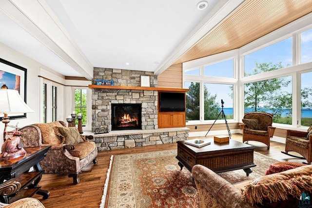 living room featuring beamed ceiling, dark hardwood / wood-style floors, and a fireplace