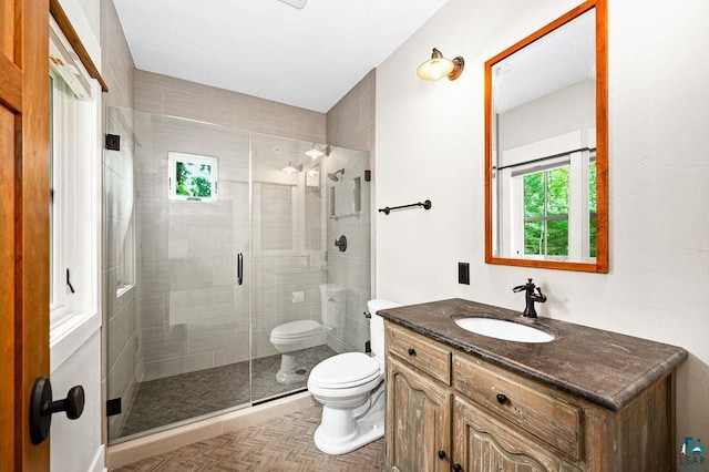 bathroom with parquet flooring, oversized vanity, toilet, and walk in shower