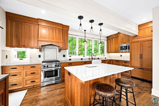 kitchen featuring backsplash, stainless steel appliances, a kitchen island, and dark hardwood / wood-style flooring