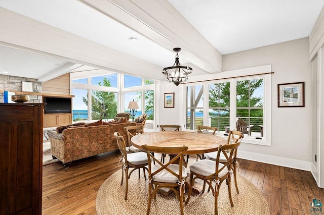 dining space with an inviting chandelier, dark wood-type flooring, a water view, and beamed ceiling