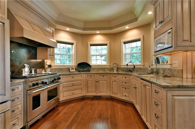 kitchen featuring white microwave, custom exhaust hood, wood-type flooring, range with two ovens, and a raised ceiling