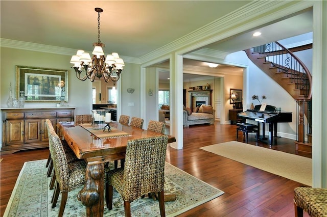 dining area featuring an inviting chandelier, crown molding, and dark hardwood / wood-style floors