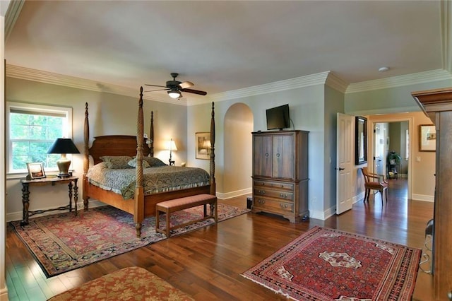 bedroom featuring dark hardwood / wood-style flooring, ceiling fan, and crown molding