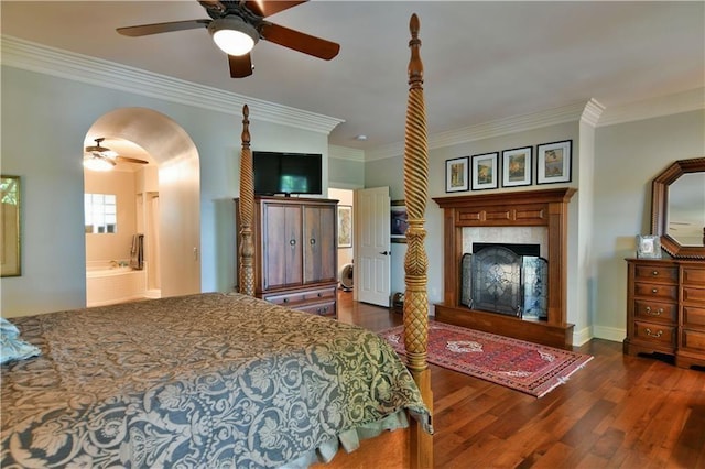 bedroom featuring ceiling fan, dark wood-type flooring, ornamental molding, and connected bathroom