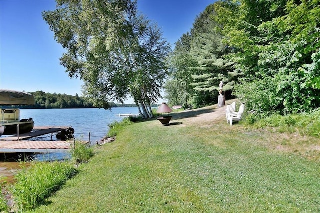 view of dock featuring a water view and a lawn