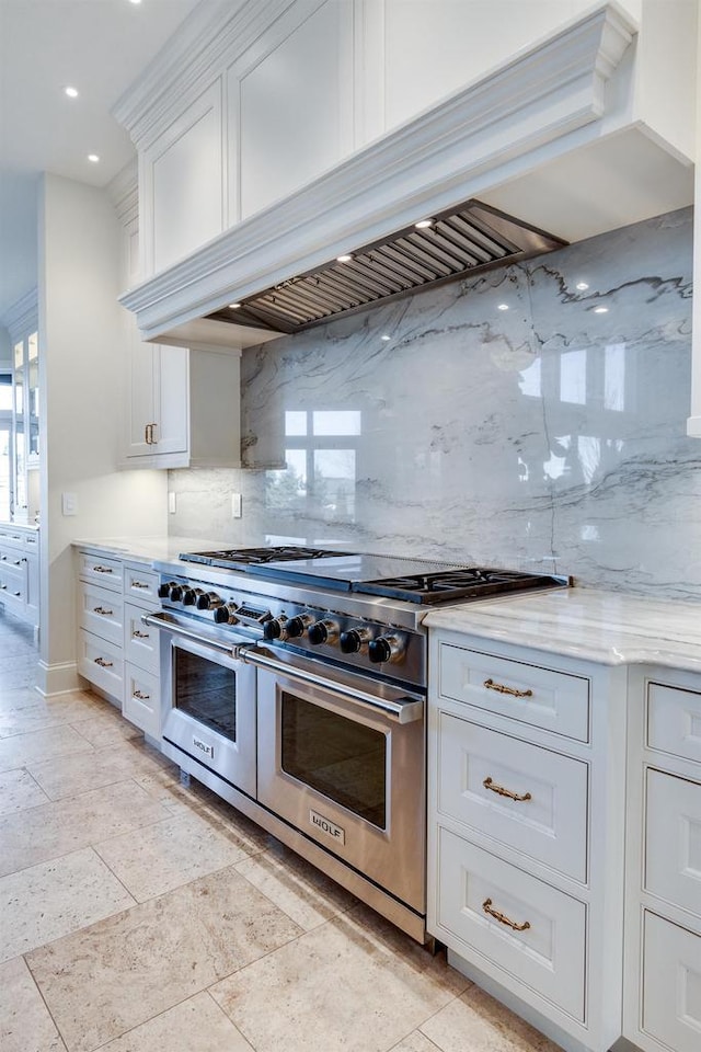 9809 Trappers Trl, Middleton, WI 53562 - kitchen featuring white cabinets, range with two ovens, premium range hood, light stone countertops, and tasteful backsplash