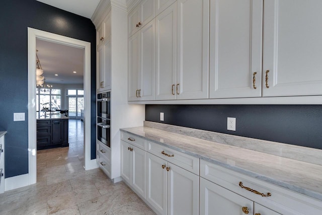 9809 Trappers Trl, Middleton, WI 53562 - kitchen with light stone countertops, double oven, white cabinets, and light tile floors