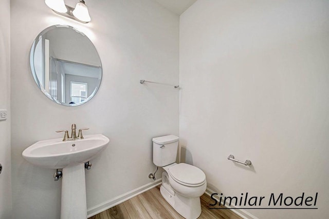 bathroom featuring toilet, wood-type flooring, and sink