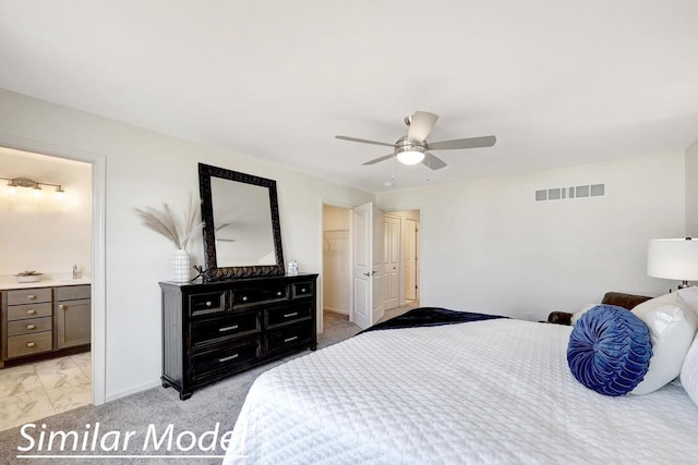 bedroom featuring a walk in closet, connected bathroom, a closet, and ceiling fan