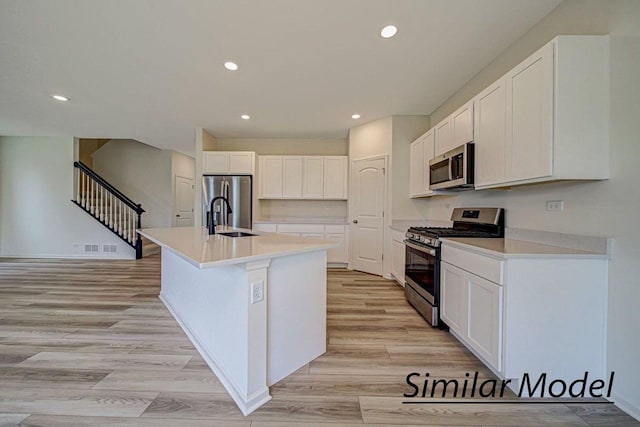 kitchen with a center island with sink, sink, white cabinetry, and stainless steel appliances