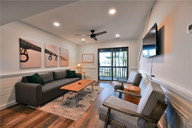 living room with ceiling fan and dark wood-type flooring