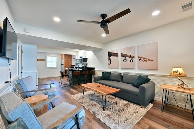 living room featuring dark hardwood / wood-style flooring and ceiling fan