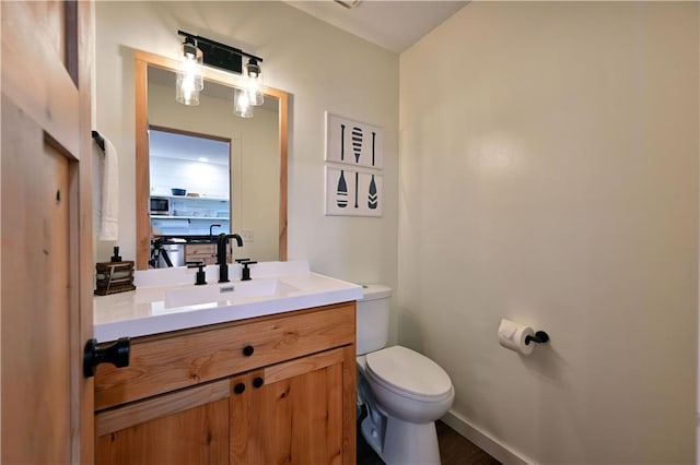 bathroom featuring toilet and large vanity