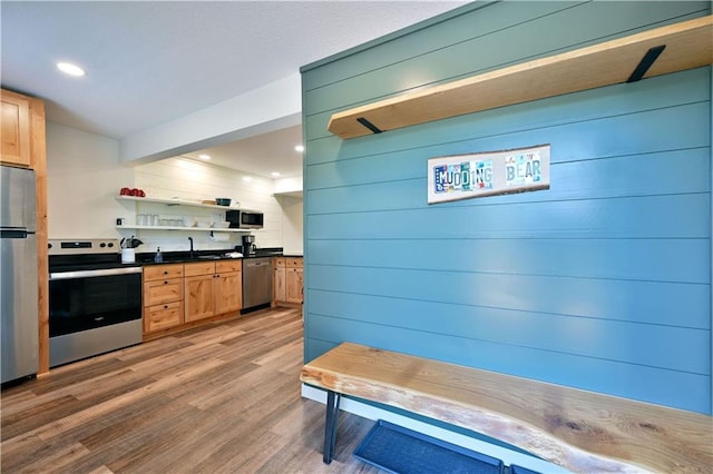 kitchen featuring appliances with stainless steel finishes, light brown cabinetry, sink, and hardwood / wood-style flooring