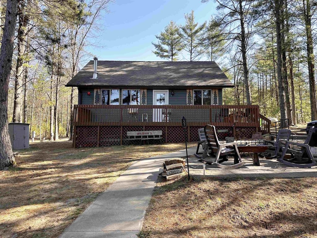 back of house featuring a deck and an outdoor structure