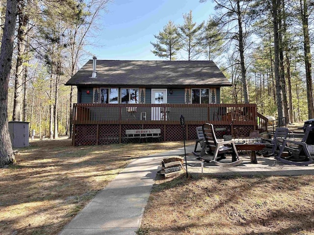 back of house featuring a deck and an outdoor structure