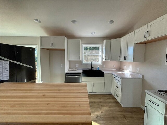 washroom with washer hookup, sink, hookup for an electric dryer, light hardwood / wood-style flooring, and cabinets