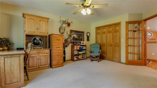 interior space featuring light colored carpet and ceiling fan