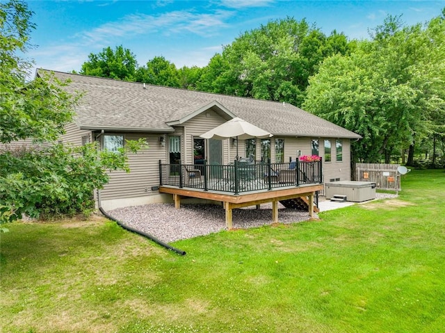 rear view of house with a hot tub, a yard, and a wooden deck