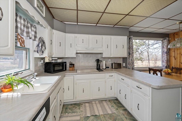 kitchen with decorative backsplash, white cabinets, stovetop, a drop ceiling, and sink