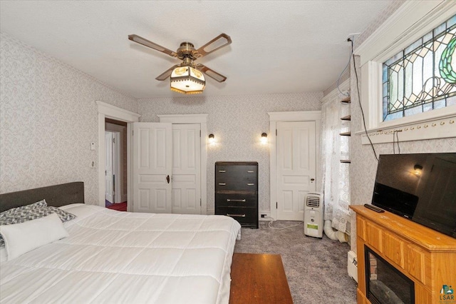 carpeted bedroom with a textured ceiling, ceiling fan, and a closet