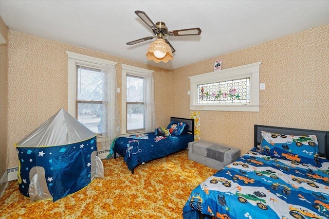 bedroom with ceiling fan and a baseboard radiator