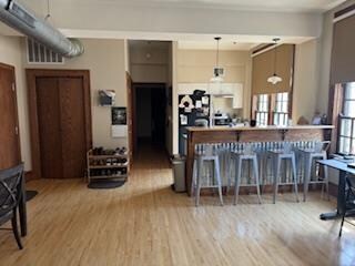 kitchen with hanging light fixtures, a breakfast bar, and light wood-type flooring