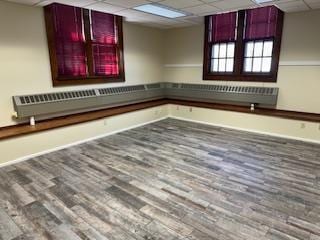 unfurnished room with hardwood / wood-style floors and a paneled ceiling