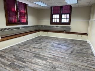 spare room with hardwood / wood-style floors and a drop ceiling