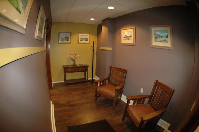 living area featuring dark hardwood / wood-style flooring and a paneled ceiling