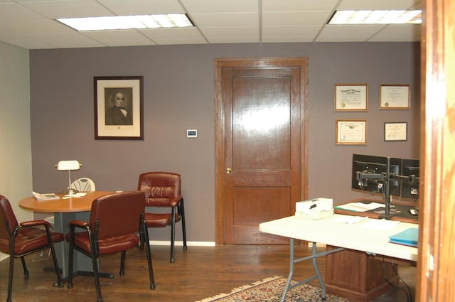 office with hardwood / wood-style flooring and a paneled ceiling