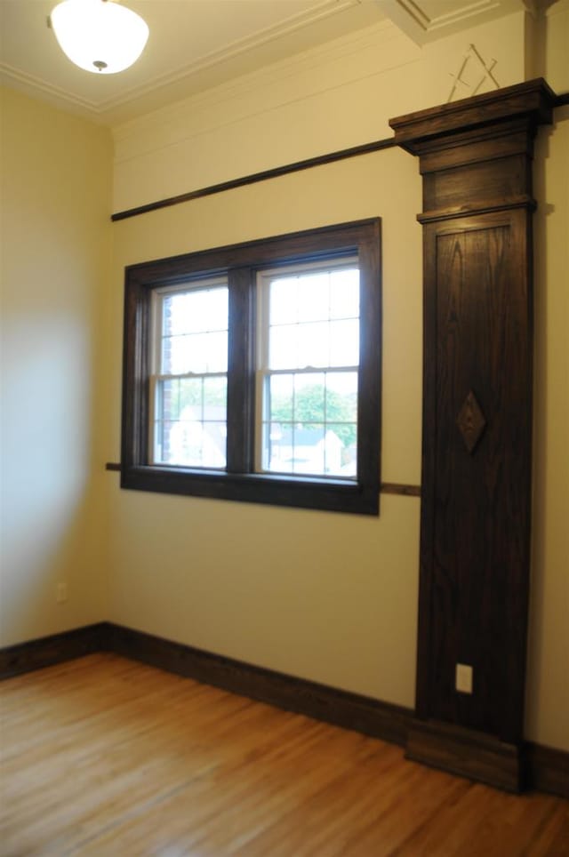 empty room featuring hardwood / wood-style floors and ornamental molding