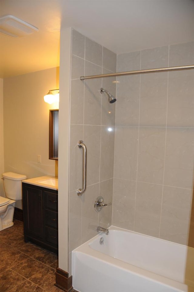 full bathroom featuring tiled shower / bath combo, vanity, tile floors, and toilet